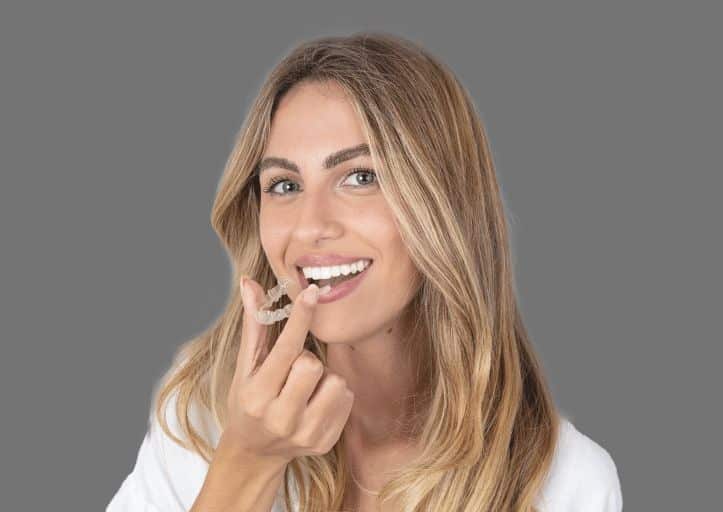 women happily using aligners