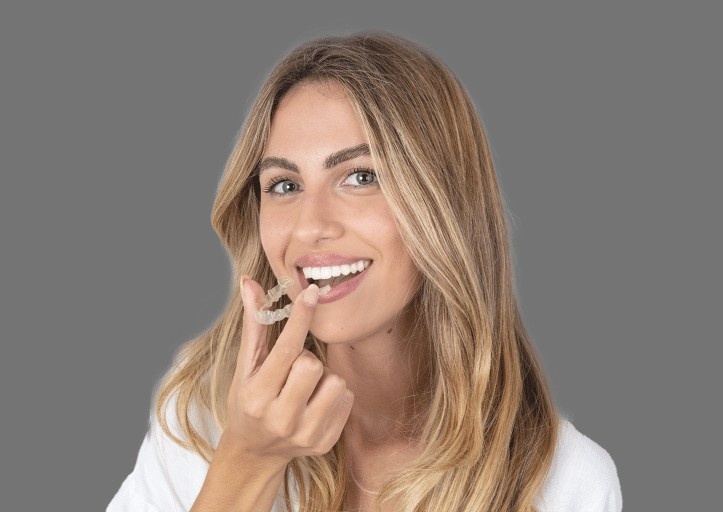 women happily using aligners