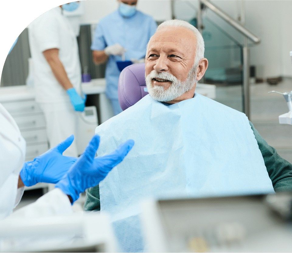 elderly man is seated in a dental chair